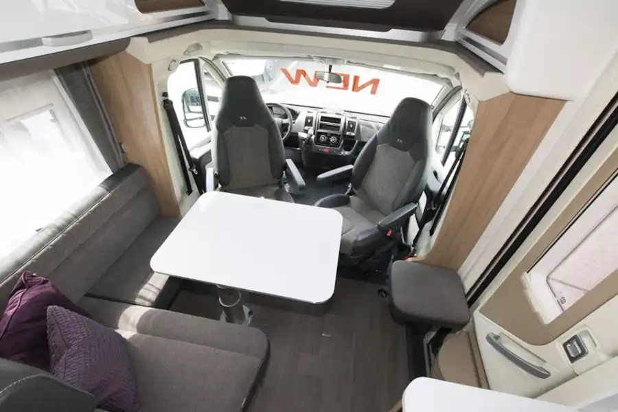 The lounge, with dining table, in the Adria Coral Axess 600 SL motorhome (Click to view full screen)