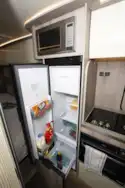 The kitchen, with fridge open, in the WildAx Elara campervan