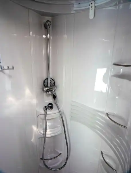 The shower is circular and has three shelves for shampoo bottles (Click to view full screen)