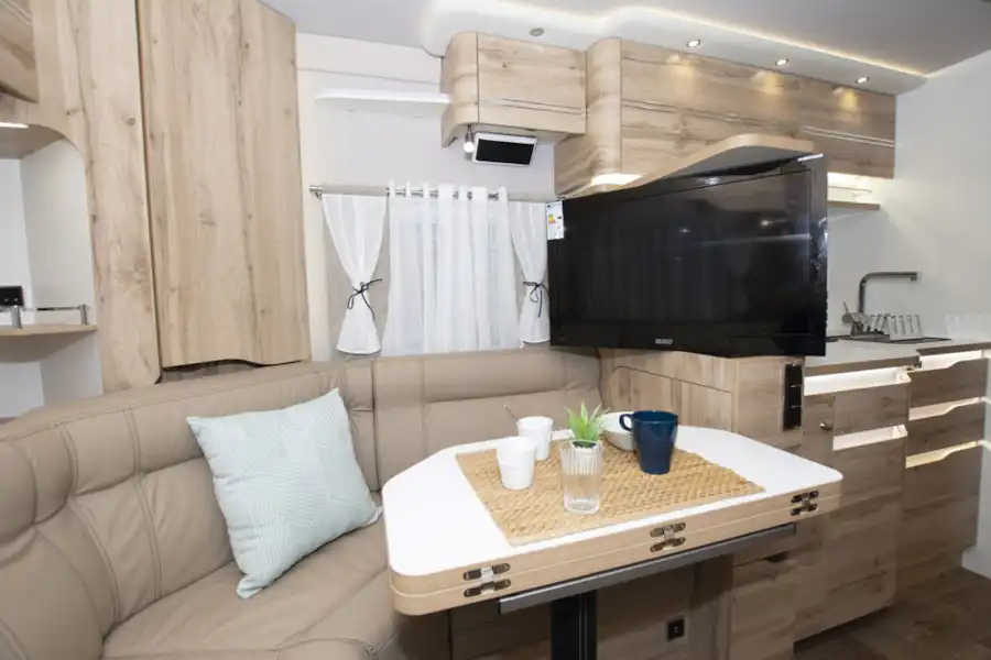 The lounge in Le Voyageur Classic LV7.8LU motorhome, with a flatscreen TV on display (Click to view full screen)