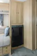 The wardrobe is above the fridge